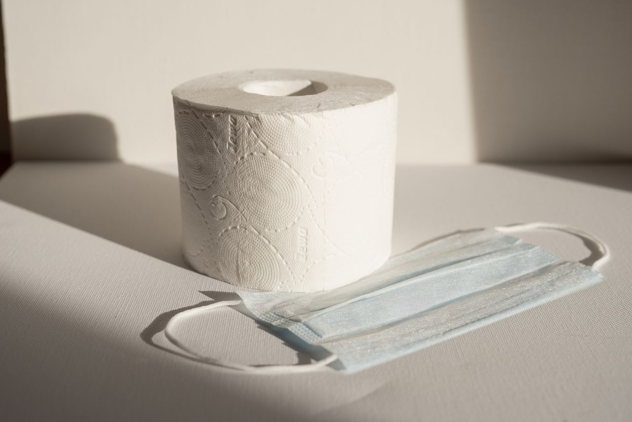 A toilet paper roll and face mask captured in natural light, symbolizing modern hygiene essentials.